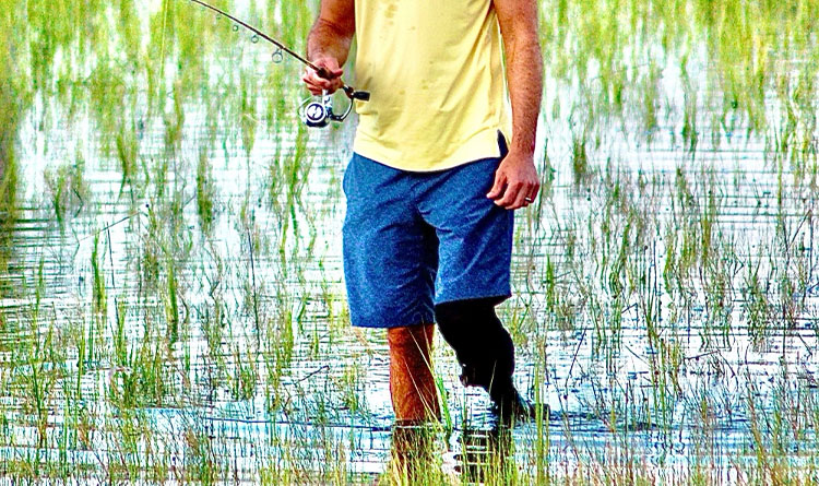 A PCOC patient wearing his prosthetic in a lake while fishing.